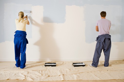 Casal trabalhando na pintura da nova casa com tinta Suvinil | Ambiente protegido para evitar bagunça e marcas de respingos