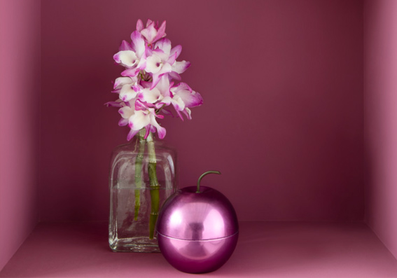 imagem de parede rosa com vaso de flor e bola de natal em frente