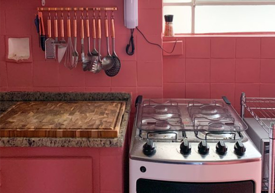 cozinha com paredes, eletrodomésticos e utensílios rosa