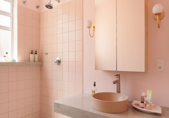 banheiro com azulejos e pia rosa