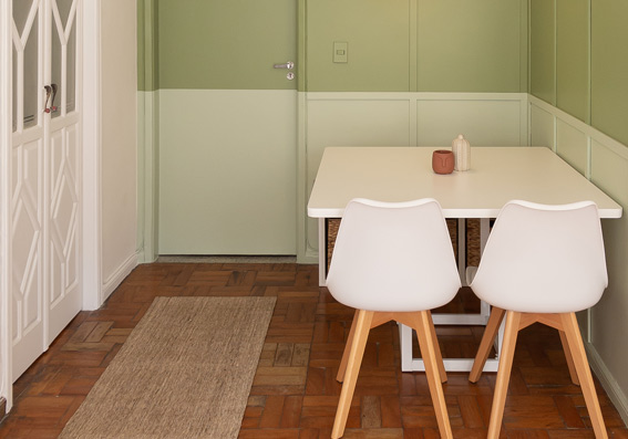 sala com parede bicolor verde com mesa e cadeiras brancas representando cores de tinta semi brilho
