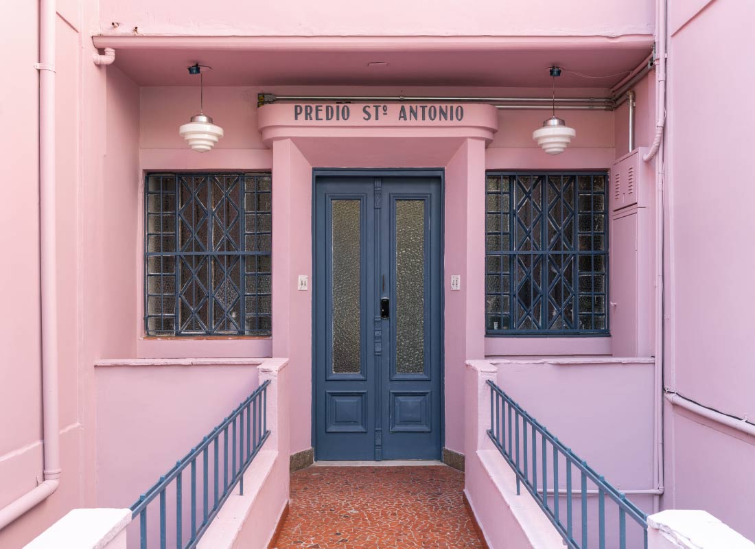 Imagem de casa pintada de rosa e com porta azul