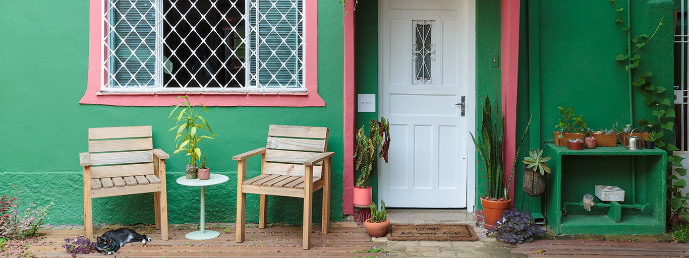 fachada de casa em verde e rosa representando cores para frente de casas simples